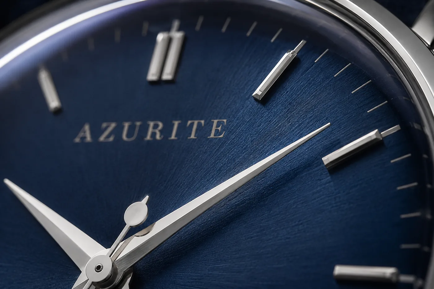 Macro of the Fathom dial between twelve and three: an applied index, the tip of the minute hand, the AZURITE wordmark