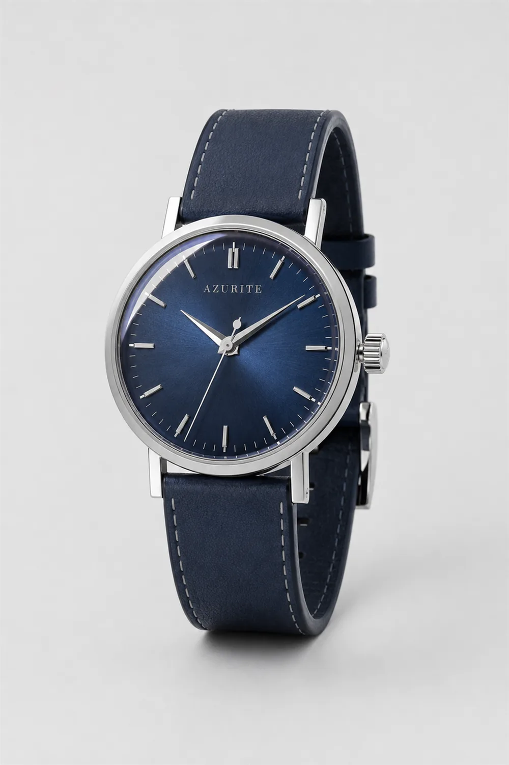 AZURITE Fathom: midnight-blue sunburst dial, polished steel case, navy calf strap, standing upright on a pale ground